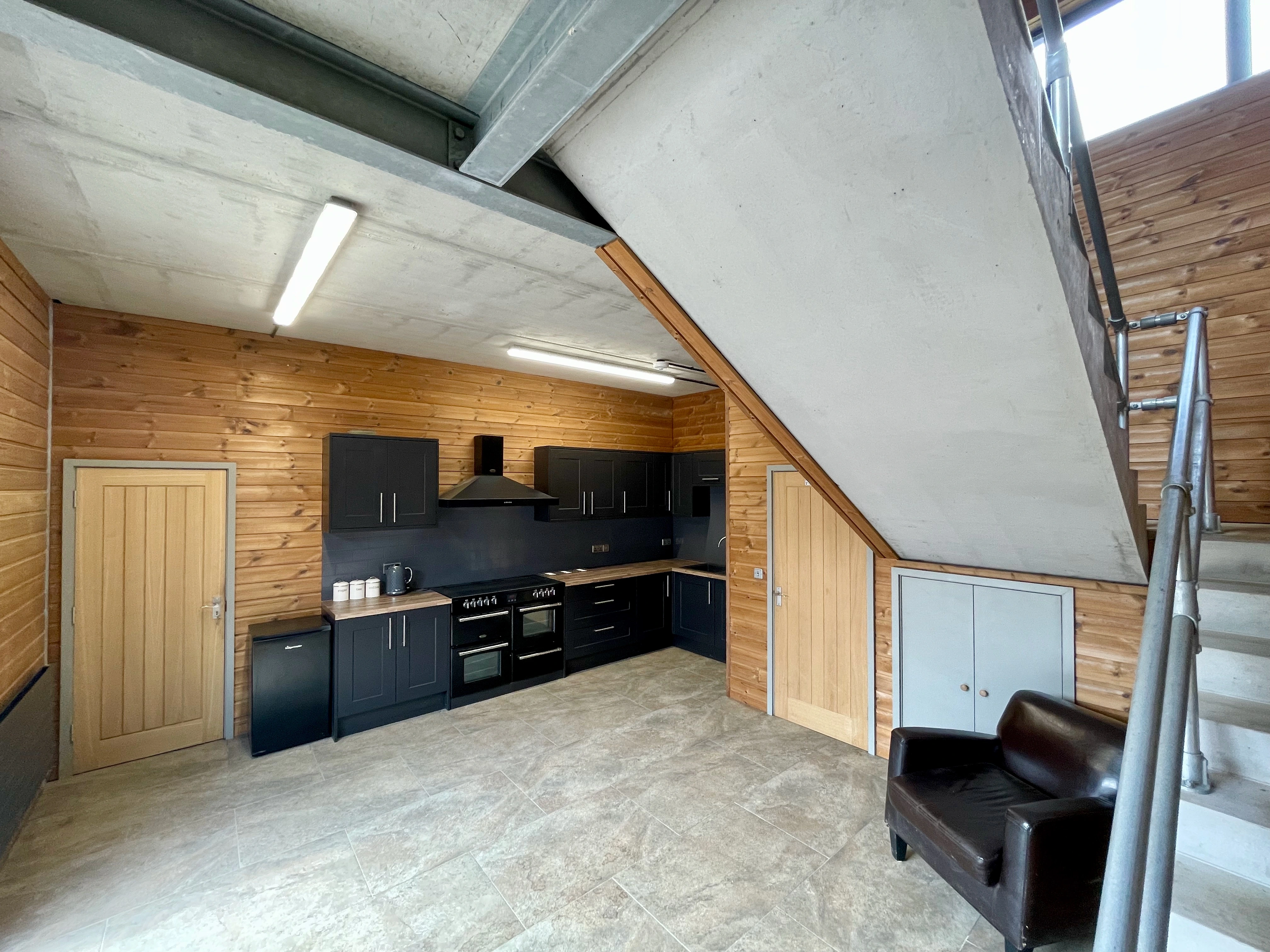 Modern kitchen with wooden countertops and dark grey cabinets.